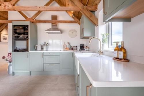 a kitchen with white countertops and wooden ceilings at 2 Bed in Blakeney oc-m42455 in Awre