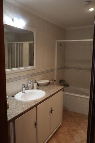 a bathroom with a sink and a bath tub at Casa do Sol in Safara