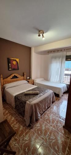 a bedroom with two beds and a window at Eclipse del Júcar Luna in Alcalá del Júcar