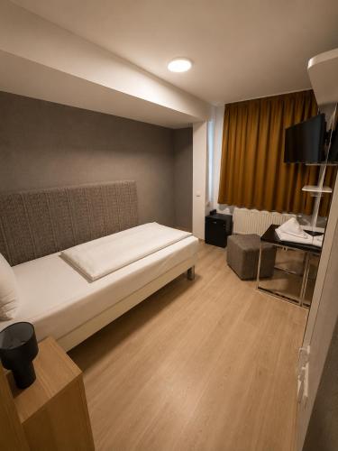 a bedroom with a bed and a desk in a room at Hotel Eurocity in Bruchköbel