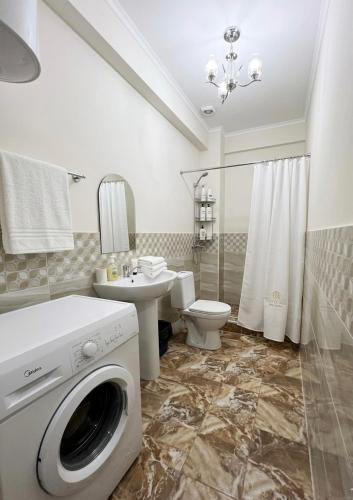 a bathroom with a washer and a toilet and a sink at Гостевой дом Кымбат in Chok-Tal