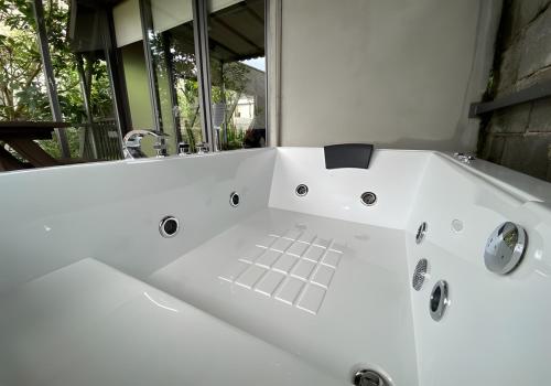 a white bath tub in a bathroom with a window at villa tibra in Lembang