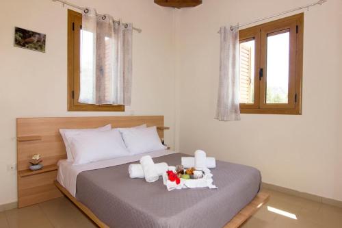 a bedroom with a bed with towels and toys on it at Emilia's Guest House with Sea View Balcony, Stoupa in Stoupa