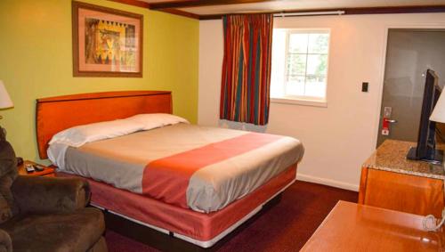 a hotel room with a bed and a couch at Relax Inn Bloomsburg in Bloomsburg