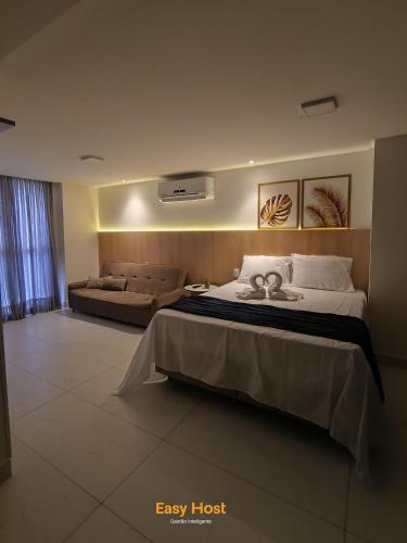 a hotel room with a bed and a couch at Flats Unity Cabo Branco - By EasyHost in João Pessoa