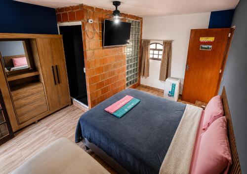 a bedroom with a bed and a brick wall at Bosque da Lua - Suite with 2 bathrooms - Up to 5 guests in Itupeva