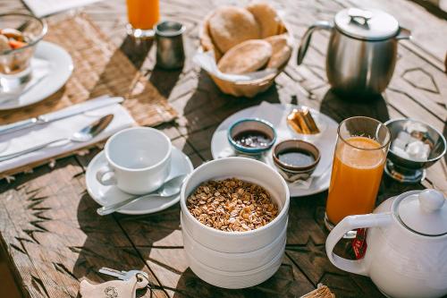 a table topped with a cup of coffee and a bowl of oats at Casa Misasha, pool & rooftop-5 suites-13 lits-hamam in Essaouira