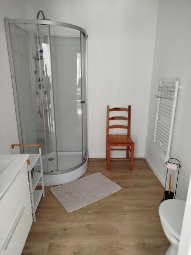 a bathroom with a shower and a wooden floor at le chardonneret in Commer