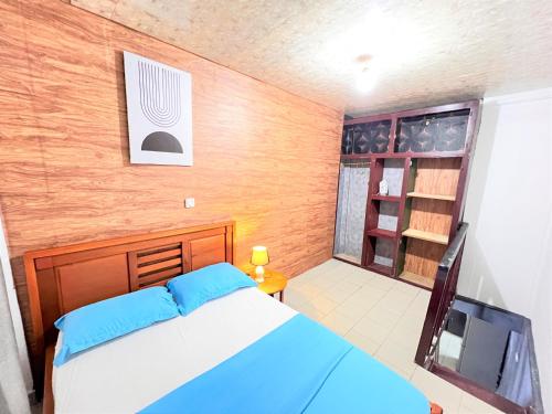 a bedroom with a blue bed and a tv at The Yafé Bastos 5 in Yaoundé