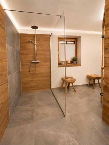 a bathroom with a shower with a glass door at EulenNest - Ferienhaus in Seeboden am Millstätter See mit Bergblick & Sauna in Seeboden