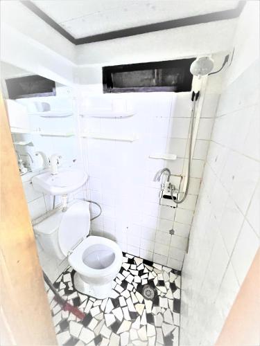 a bathroom with a toilet and a sink at The Yafé Bastos 5 in Yaoundé