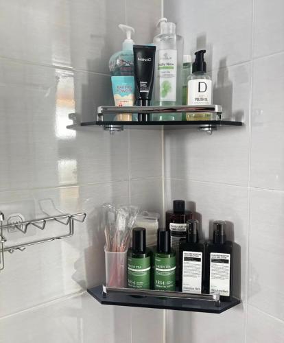 a bathroom shelf with bottles ofodorizers and cosmetics at Coco House in Daejeon