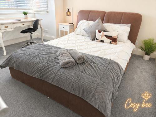 a bedroom with a bed with a desk and a chair at Cosy Bee in Bournemouth