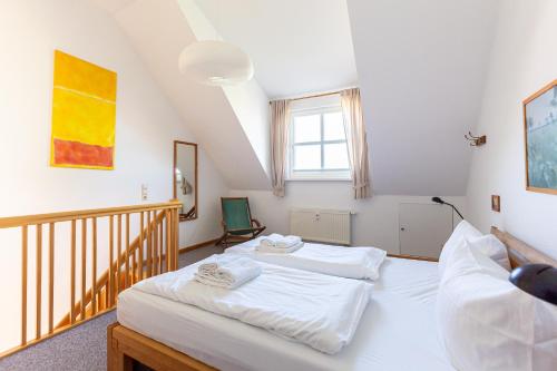 a bedroom with two beds and a staircase at Kiek Över in Ahrenshoop