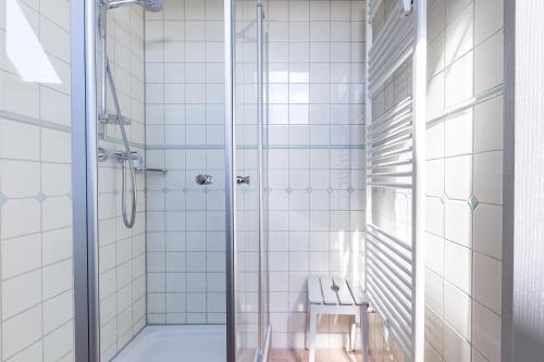 a bathroom with a shower with white tiles at Kiek Över in Ahrenshoop