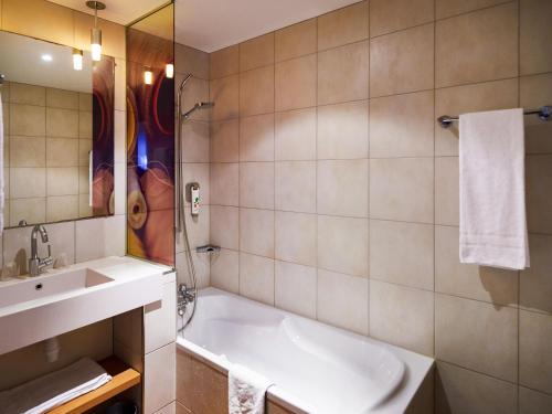 a bathroom with a sink and a bath tub at ibis Styles Cholet in Cholet