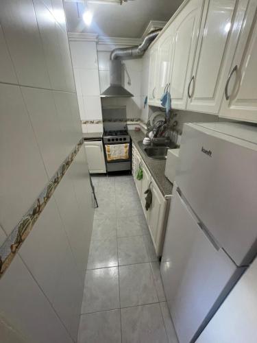 a small kitchen with white cabinets and a stove at my house in Lisbon