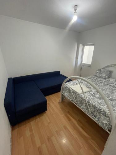 a room with a blue couch and a bed at my house in Lisbon