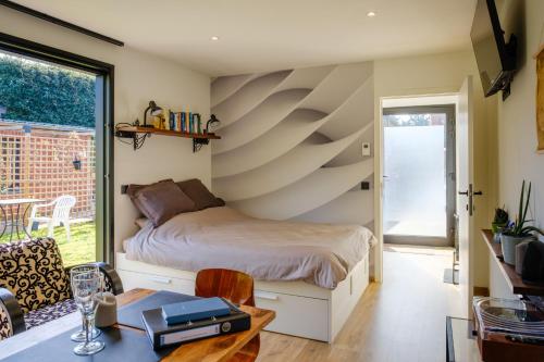 ein Schlafzimmer mit einem Bett und einem Tisch in einem Zimmer in der Unterkunft Recup in Beernem