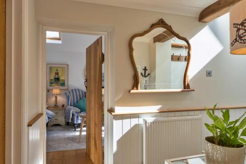 a hallway with a mirror and a living room at Finest Retreats - The Rectory Nook Annexe in Saint Teath