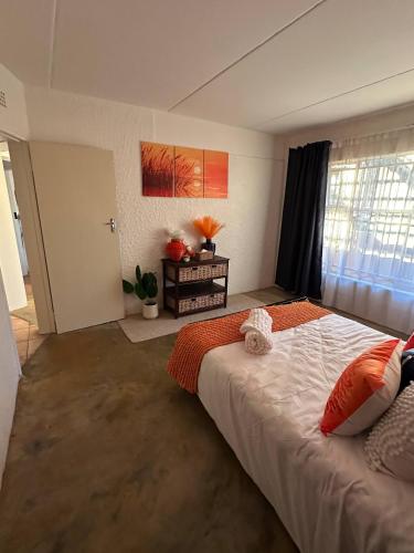 a bedroom with a large bed and a window at Retro at The Vaal - entire Flat in Denysville