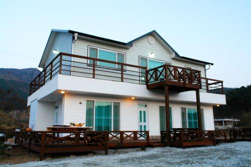 a large house with a balcony and a deck at Buan Solseom House Pension in Buan
