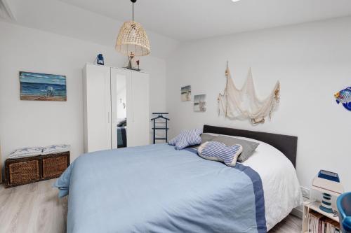 a white bedroom with a large bed with blue sheets at Chambre D'hôtes - Chambre Marine in La Plaine-sur-Mer