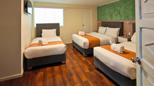 a hotel room with three beds and a window at Hotel Terrazas del sol in Arequipa