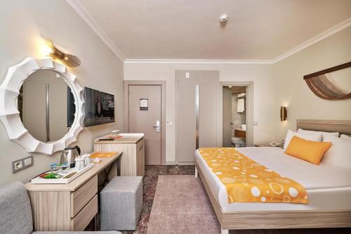 a hotel room with a bed and a sink and a mirror at Fun Sun Smart Akman Beach in Kemer