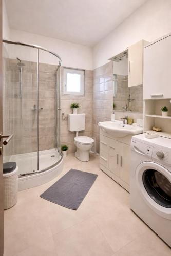 a bathroom with a toilet sink and a washing machine at Holiday Home Pakoštane in Pakoštane