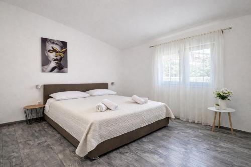 a bedroom with a bed with two towels on it at Holiday Home Pakoštane in Pakoštane