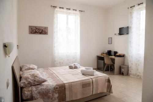 a white bedroom with a bed and a desk at Bed And Breakfast Nonna Pia in Fertilia