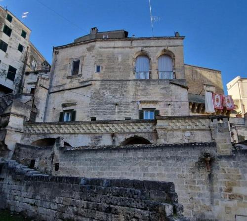 an old building with windows on top of a brick wall at Vistasassi rooms in Matera