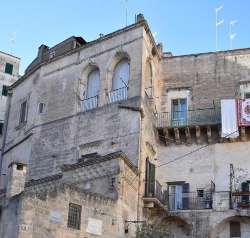 an old building with two windows and a balcony at Vistasassi rooms in Matera
