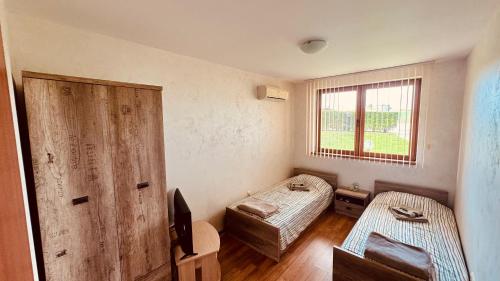 a small room with two beds and a window at EGGO APARTMENT - Oasis Beach Apartments Kamchia in Dolen Bliznak