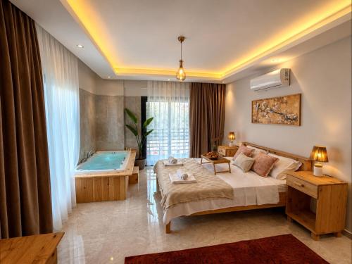 a hotel room with a bed and a bath tub at As Villas Villa Asil in Fethiye