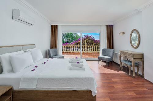 a bedroom with a bed and a desk and a window at TEKCE Villa Motto N21 in Kaş