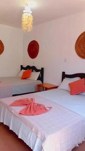 a bedroom with two beds with red and white sheets at BELL MAR CHALéS 01e 02 in Luis Correia