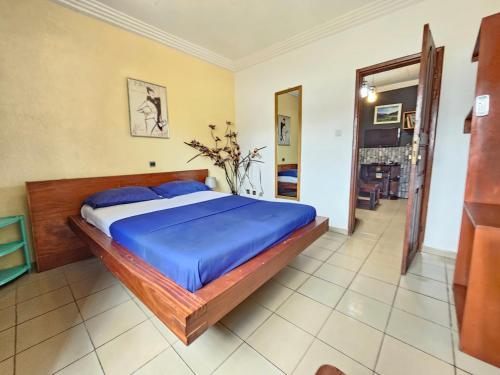 a bedroom with a large bed with blue pillows at The Yafé Bastos 6 in Yaoundé