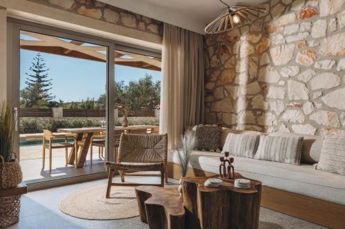 a living room with a couch and a stone wall at Bedrock beachside villa with private pool in Vasilikos