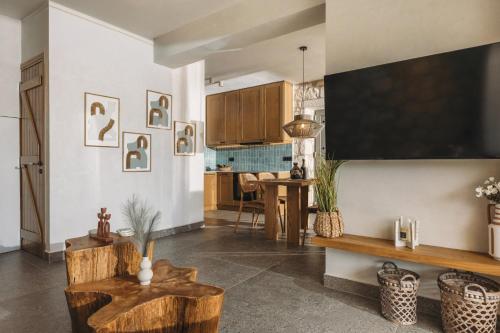 a living room with a large television and a table at Bedrock beachside villa with private pool in Vasilikos