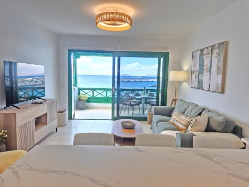 a living room with a couch and a view of the ocean at Casa Balcón del Puerto in Playa Blanca
