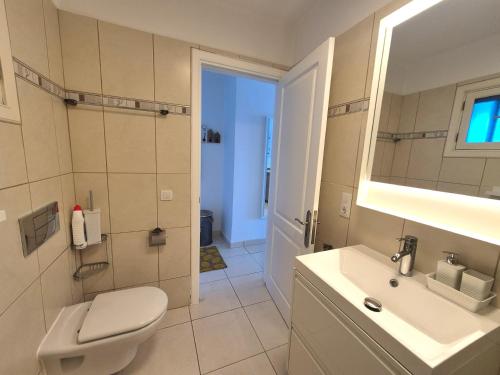 a white bathroom with a toilet and a sink at Casa Balcón del Puerto in Playa Blanca