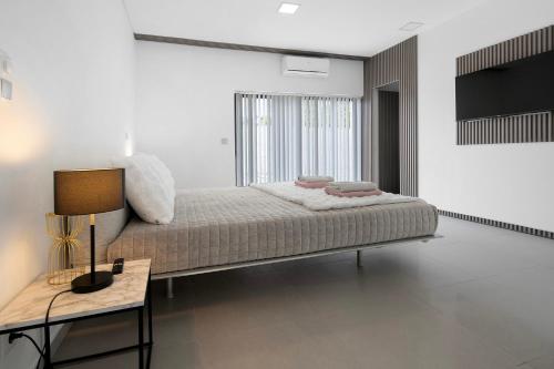 a bedroom with a bed and a table with a lamp at Bella Casa - piso inferior in Angra do Heroísmo