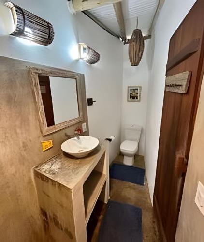 a bathroom with a sink and a toilet at Pousada Aratu - Vila de Caraíva - A apenas 100 metros da travessia de canoa in Caraíva