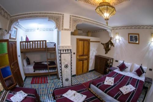 a bedroom with two beds and a bunk bed at Dar al haja rahma in Fez