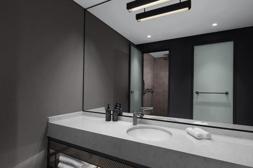 a bathroom with a sink and a large mirror at Aloft by Marriott Istanbul Karakoy in Istanbul