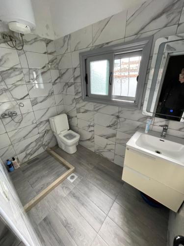 a bathroom with a toilet and a sink at Flag's Square House Vlore in Vlorë