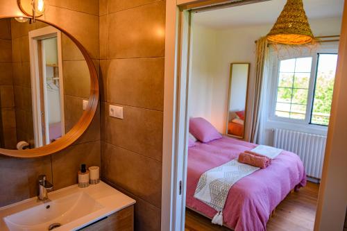 a bedroom with a bed and a sink and a mirror at Amama Baita in Urrugne