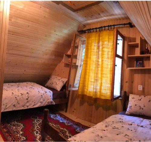 a bedroom with two beds and a window at Black Lake House Dajovic in Žabljak